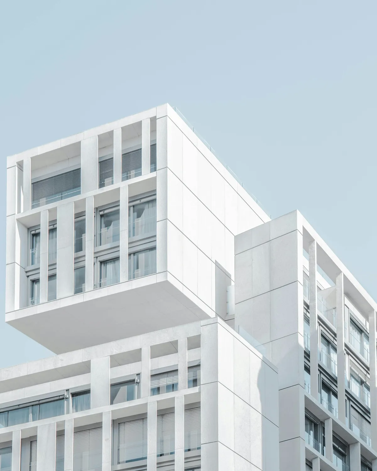 A bright modern building rising into a clear blue sky